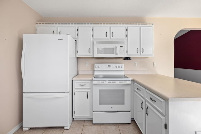 kitchen featuring white appliances, light countertops, a peninsula, and light tile patterned flooring