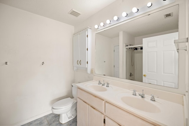 full bathroom featuring toilet, a sink, visible vents, and a shower stall