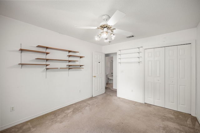 unfurnished bedroom featuring baseboards, visible vents, a ceiling fan, carpet flooring, and a closet