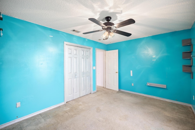 unfurnished bedroom featuring carpet floors, a closet, visible vents, a textured ceiling, and baseboards