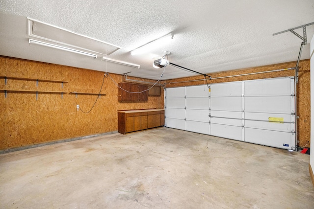 garage featuring a garage door opener and wooden walls