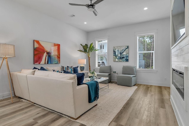 living room featuring visible vents, plenty of natural light, and light wood finished floors