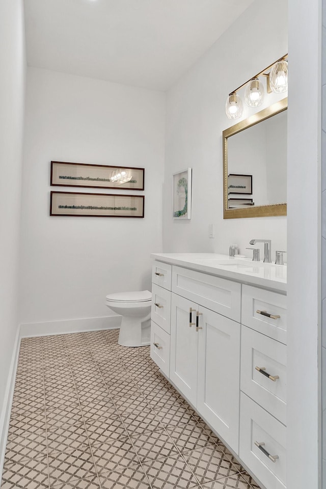 bathroom with baseboards, vanity, and toilet