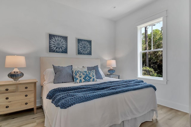 bedroom with light wood-type flooring and baseboards