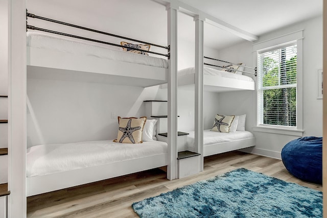 bedroom with baseboards and wood finished floors