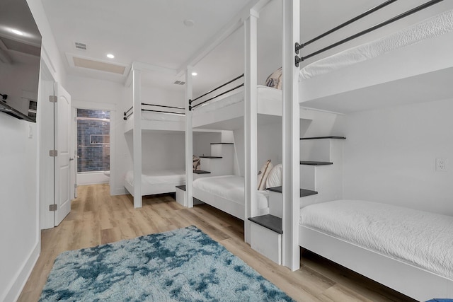 bedroom with attic access, wood finished floors, visible vents, and recessed lighting