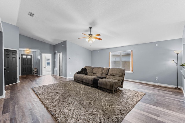 living area with lofted ceiling, wood finished floors, a ceiling fan, visible vents, and baseboards