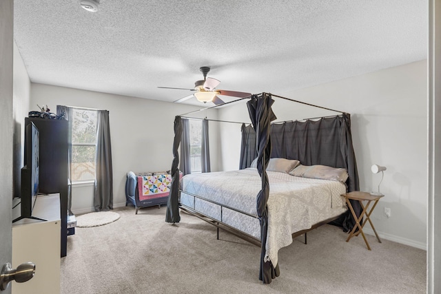 carpeted bedroom with a ceiling fan, a textured ceiling, and baseboards