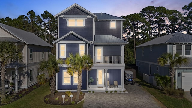 view of front of house featuring metal roof and a balcony