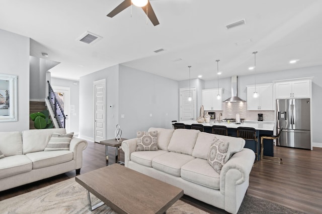 living area with stairs, dark wood-type flooring, and visible vents