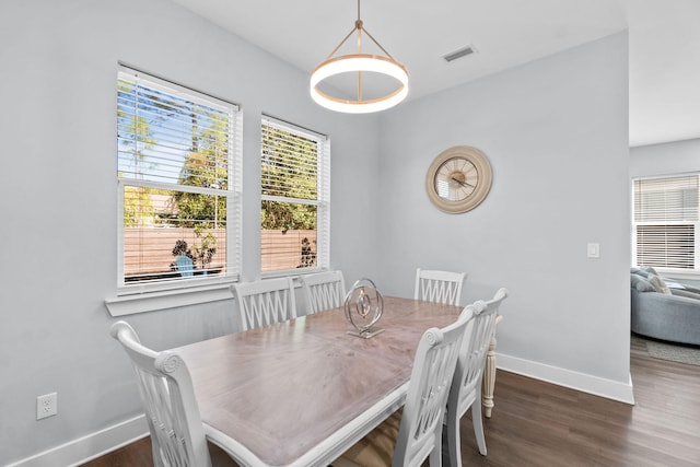 dining space featuring dark wood finished floors, visible vents, and baseboards