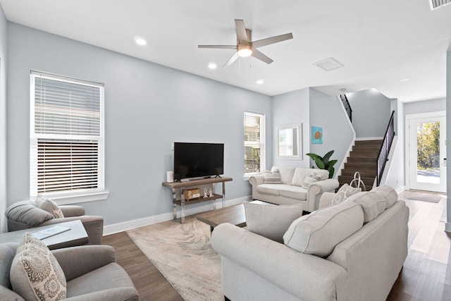 living area featuring recessed lighting, dark wood-type flooring, a ceiling fan, baseboards, and stairs