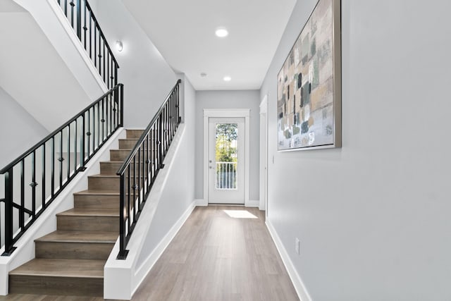 entryway featuring stairway, baseboards, wood finished floors, and recessed lighting