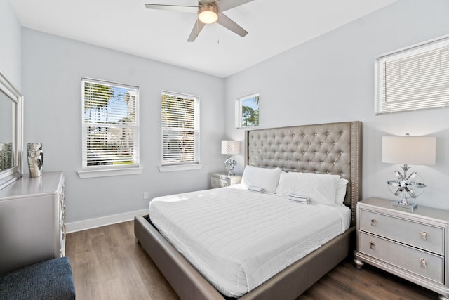 bedroom with dark wood-style floors, ceiling fan, and baseboards