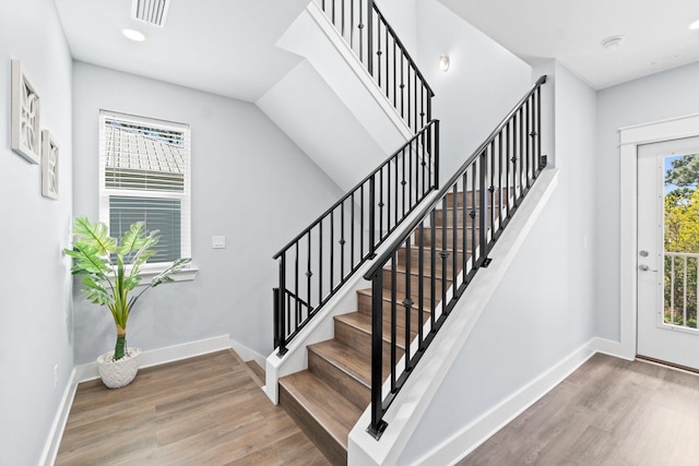 staircase featuring visible vents, baseboards, and wood finished floors