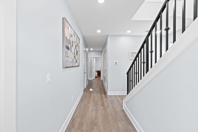 hall with recessed lighting, wood finished floors, baseboards, and stairs