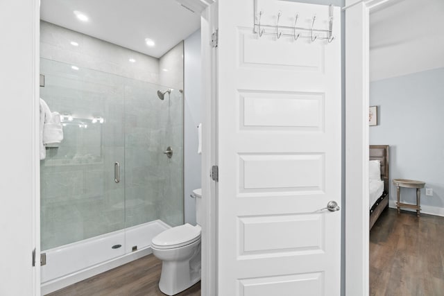 ensuite bathroom featuring ensuite bathroom, wood finished floors, toilet, and a shower stall