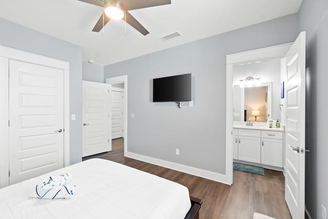 bedroom featuring baseboards, visible vents, dark wood finished floors, a ceiling fan, and ensuite bath