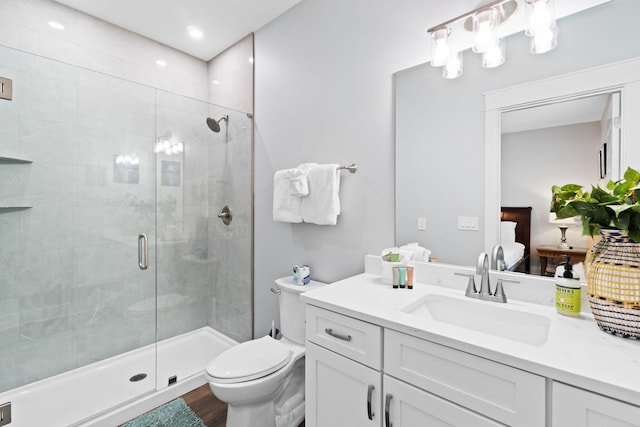 full bath featuring vanity, wood finished floors, a shower stall, and toilet