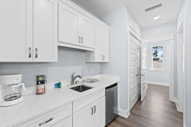 kitchen with a sink, visible vents, baseboards, white cabinetry, and stainless steel dishwasher