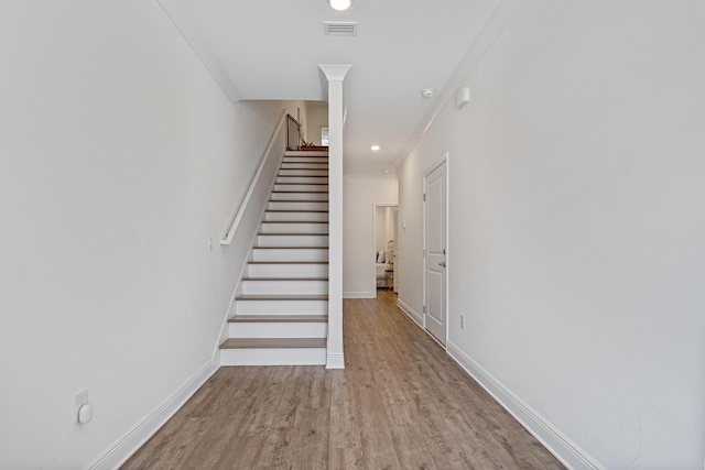 stairway with visible vents, baseboards, and wood finished floors