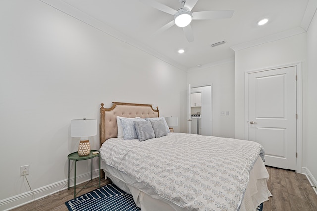 bedroom with visible vents, crown molding, baseboards, and wood finished floors