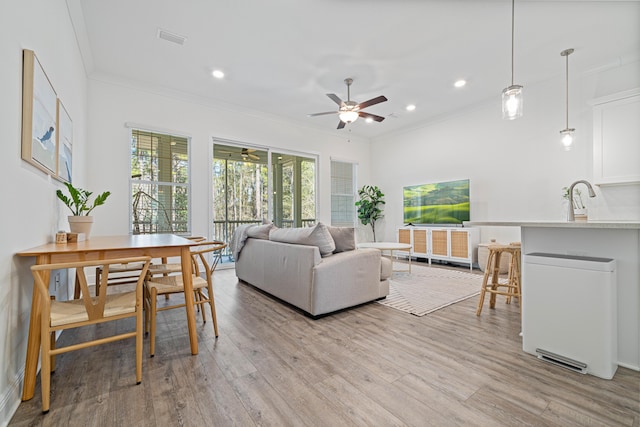 living area featuring visible vents, ceiling fan, crown molding, light wood-type flooring, and recessed lighting