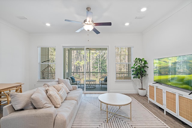 living area with visible vents, a ceiling fan, ornamental molding, wood finished floors, and recessed lighting