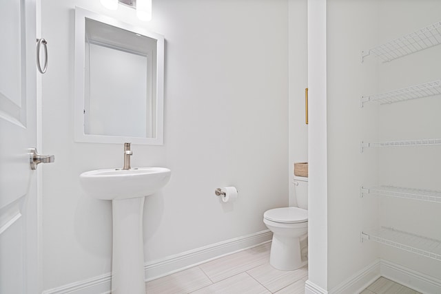 bathroom featuring toilet and baseboards