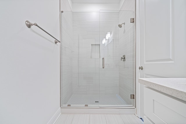 full bathroom with tile patterned flooring, a shower stall, and vanity