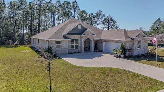 view of front of property with a garage, brick siding, a shingled roof, concrete driveway, and a front yard