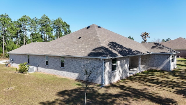 279 Tournament Ln, Freeport, FL 32439 - view of property exterior featuring a yard, brick siding, roof with shingles, and cooling unit