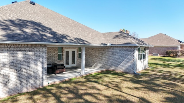 279 Tournament Ln, Freeport, FL 32439 - back of property with a shingled roof, french doors, a patio area, and a lawn