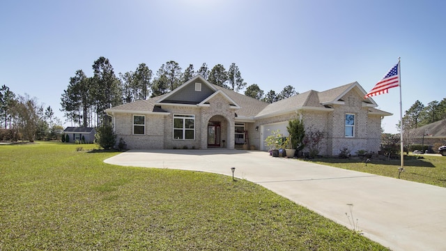 view of front of property featuring an attached garage, brick siding, driveway, and a front lawn