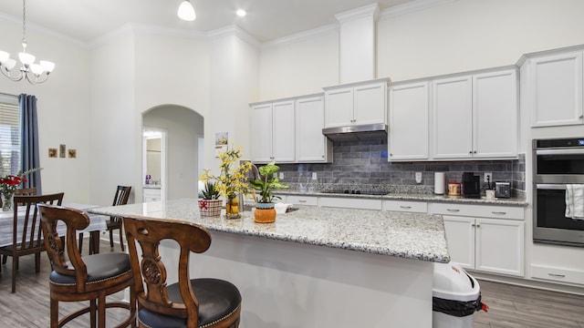 279 Tournament Ln, Freeport, FL 32439 - kitchen with arched walkways, double oven, a breakfast bar area, tasteful backsplash, and crown molding
