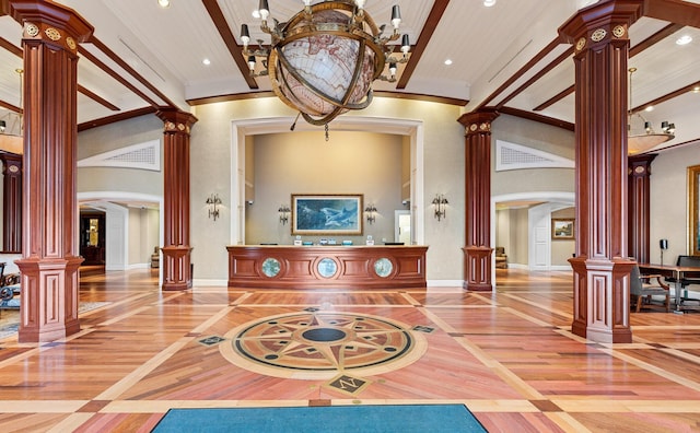 welcome area featuring arched walkways, decorative columns, and an inviting chandelier