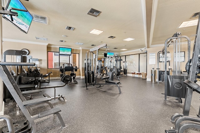 gym with a textured ceiling, ornamental molding, visible vents, and baseboards