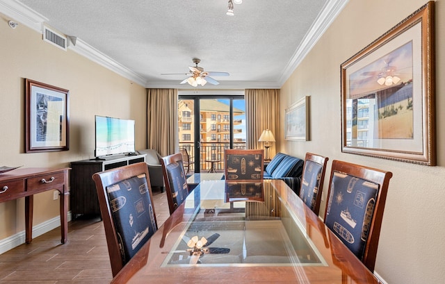 dining room with ornamental molding, visible vents, a textured ceiling, and a ceiling fan