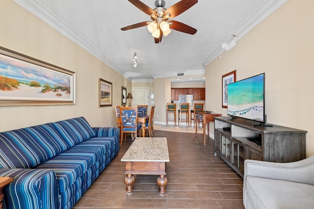 living area with ceiling fan, visible vents, baseboards, ornamental molding, and wood tiled floor