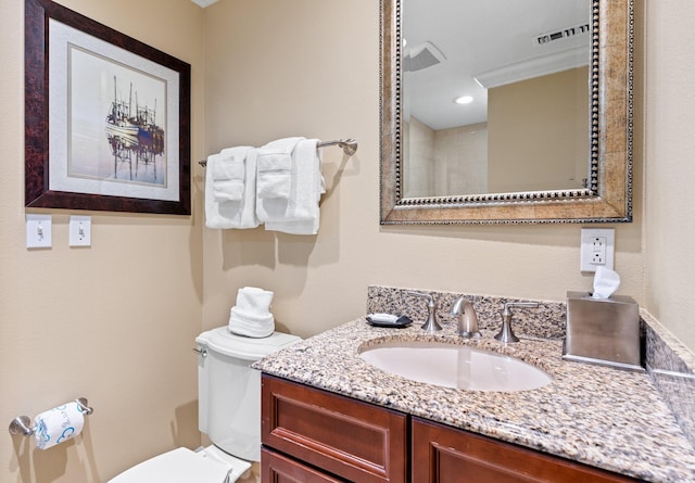 bathroom with visible vents, vanity, and toilet