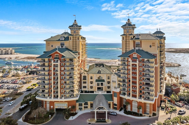 view of building exterior with a water view and a beach view