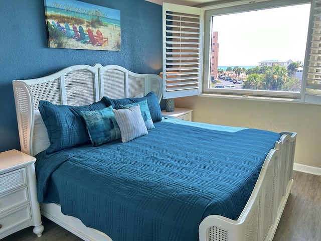 bedroom featuring baseboards and wood finished floors