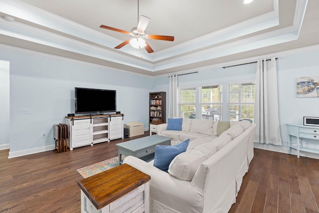 living area featuring a tray ceiling, dark wood-style flooring, and crown molding