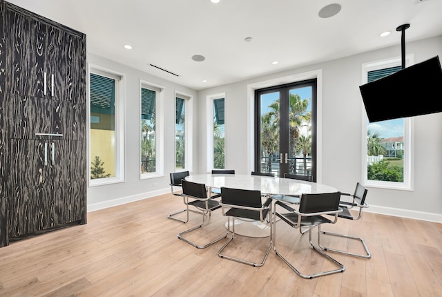 dining space with french doors, plenty of natural light, wood finished floors, and baseboards