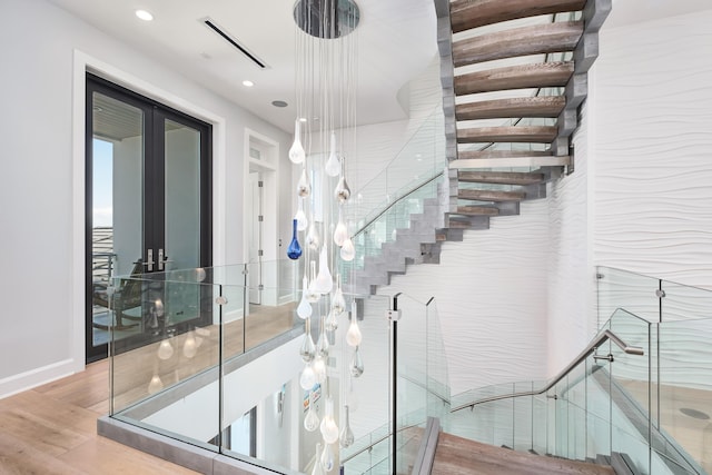 stairway with wood finished floors, visible vents, and recessed lighting