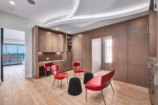 living area with light wood-type flooring, built in desk, and recessed lighting