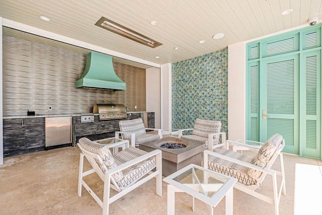 view of patio with an outdoor fire pit, an outdoor kitchen, and area for grilling