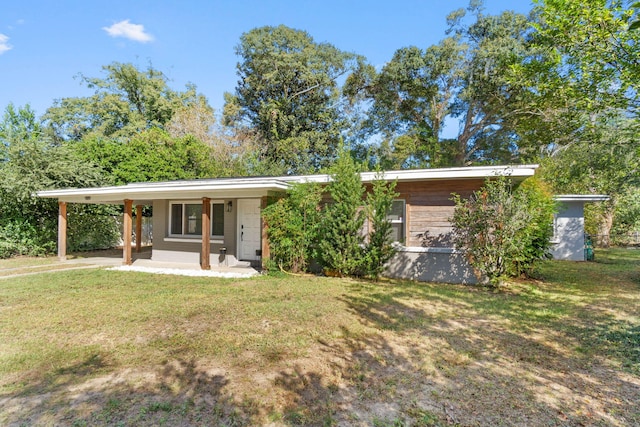 view of front facade with a front lawn and an attached carport