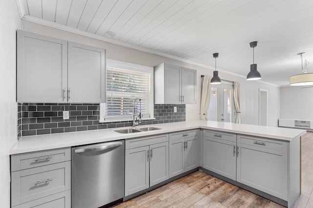 kitchen featuring light countertops, gray cabinetry, a sink, dishwasher, and a peninsula