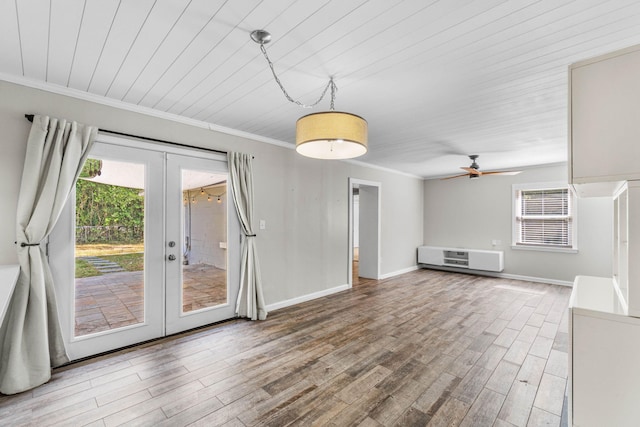 unfurnished living room featuring baseboards, french doors, wood finished floors, and crown molding